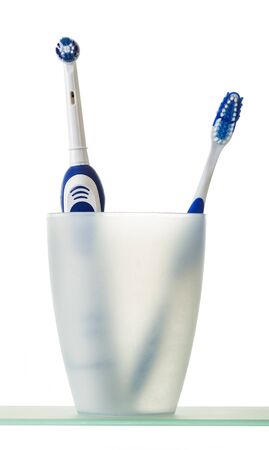 In glass is electric and manual toothbrush, isolated on white backgroundの写真素材