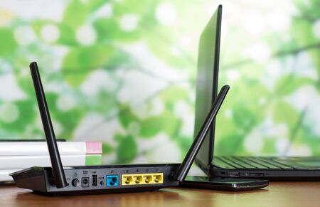 Laptop, smartphone and Wi-Fi router, folders with documents on desktopの写真素材
