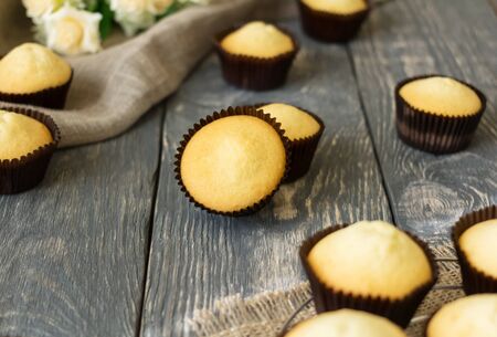 Fragrant pastries - ready cupcakes in molds, on wooden surfaceの写真素材