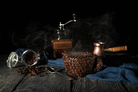 Manual coffee mill, cup of coffee beans, and turka isolated on black backgroundの写真素材