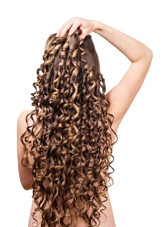 Woman with shiny brown curls isolated on a white background. Back view.の写真素材
