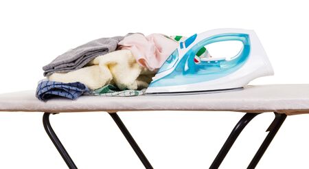 Steam iron, ironing board and clothes isolated on white background.の写真素材