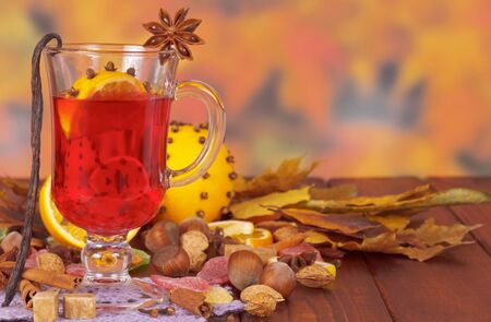 Mulled wine, nuts and sweets on the background of autumn leaves.の写真素材