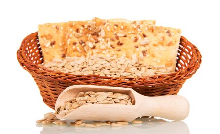Basket with peeled sunflower seeds and biscuits, wooden scoop isolated on white background.の写真素材