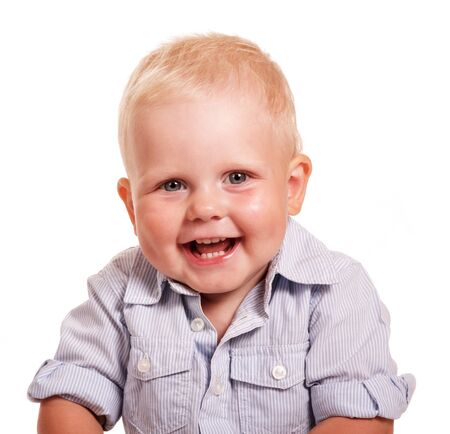 Portrait of a cheerful little boy in a bright striped shirt isolated on white background.の写真素材