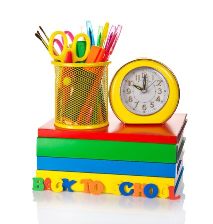 Stack of textbooks, stationery set and alarm clock isolated on white background.の写真素材