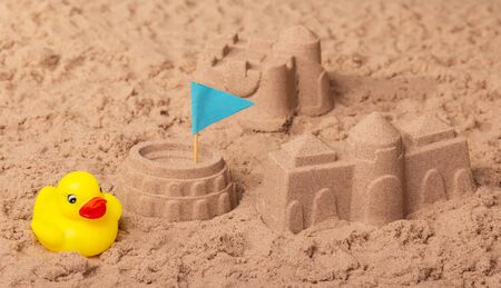 Castles and Coliseum with a flag, a rubber duck in the sand. Background.の写真素材