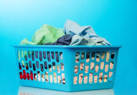 Plastic basket with clothes washing on a blue background.の写真素材