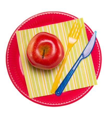 Colorful disposable plates, plastic and fork, apple, napkin isolated on white background.の写真素材