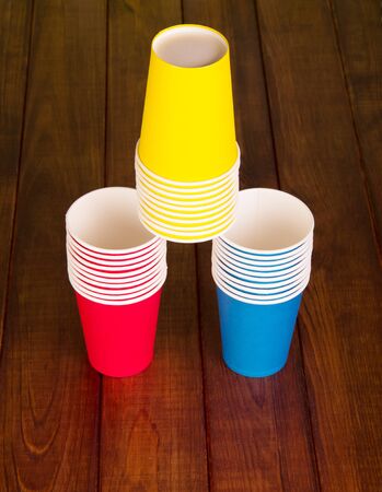 Pyramid of colorful disposable paper cups on the background of dark wood.の写真素材