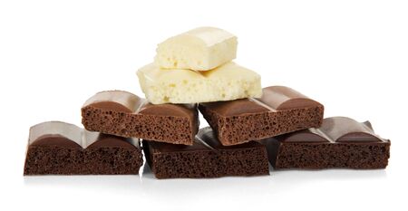 Stack of porous chocolate pieces in different colors isolated on white background.の写真素材
