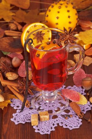 Mulled wine, oranges, nuts and sweets on the background of autumn leaves.の写真素材