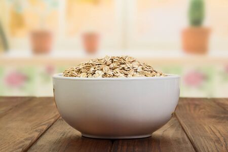 A bowl of oatmeal on the background of the kitchen.の写真素材