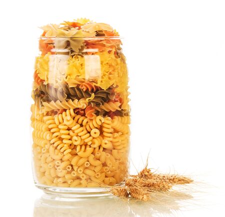Different colored pasta in a glass jar isolated on white background.の写真素材