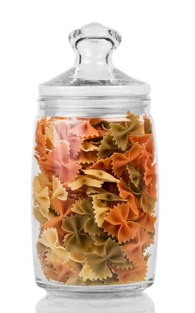 Jar of colored pasta Farfalle isolated on white background.の写真素材