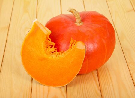 Whole ripe pumpkin and a piece of wood against the light.の写真素材