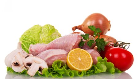 Raw chicken legs and vegetables for cooking isolated on white background.の写真素材