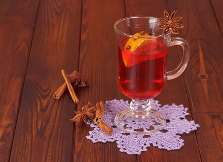Mulled wine with orange, cloves, anise and cinnamon on a background of dark wood.の写真素材