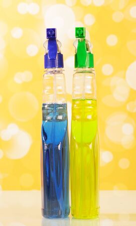 Spray bottles cleaning agent on an abstract yellow background.の写真素材
