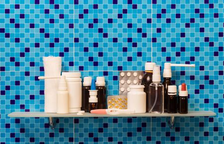 Shelf in a bathroom with a pregnancy test, medication and pills, bandage on abstract blue background.の写真素材