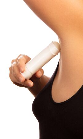 An unidentified woman uses a dry underarm deodorant isolated on white background.の写真素材