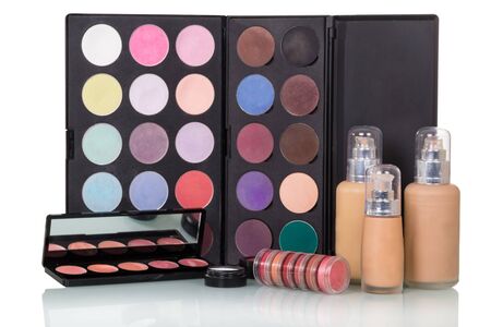 Set of eye shadows and lipsticks, bottles of liquid foundation isolated on white background.の写真素材