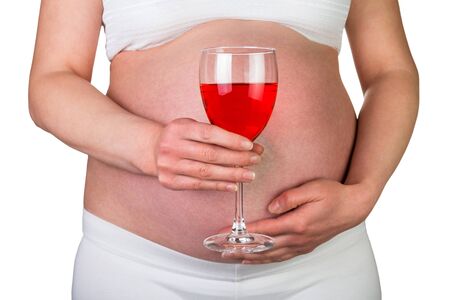Pregnant woman with a glass of red wine in hand isolated on white background.の写真素材