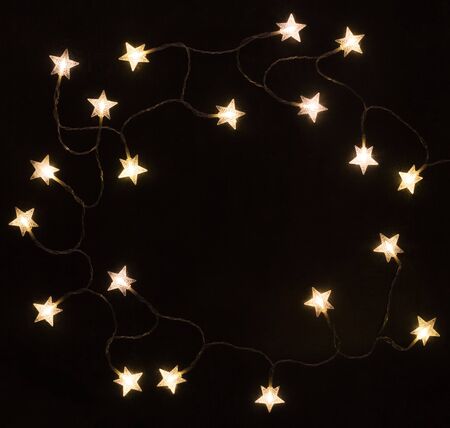 Garland of luminous yellow stars on a black background. Textureの写真素材