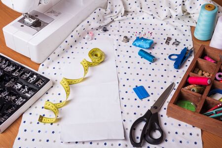 Pastel color background, Dressmaker and designer desk, Handcraft accessories: threads roll, scissors and button. Close up.の写真素材