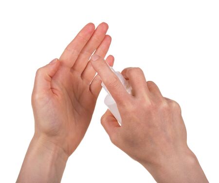 Female hand sprays on another spray sanitizer. Shot close-up and isolated on a white background.の写真素材