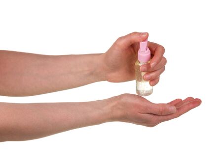 Female hands spray the sanitizer in the palm of the hand. Close-up isolated on a white background.の写真素材