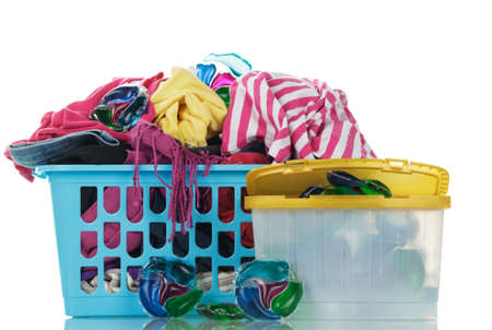 Multi-colored dirty laundry in a basket and capsules for washing clothes with concentrated gel