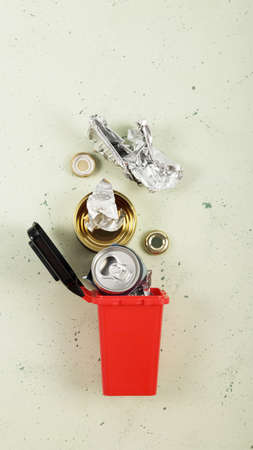 Sorting of household waste. Waste recycling. Waste container of red color with metal waste, beer...