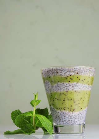 Delicious and healthy dessert with chia seeds and fresh kiwi puree on gray backgroundの写真素材