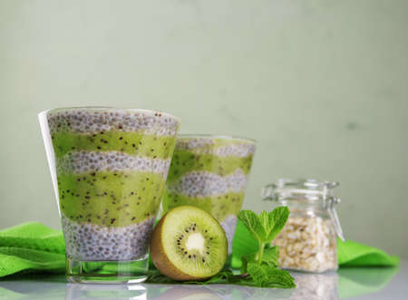 The concept of dietary proper nutrition. Protein-rich chia seeds in the form of a mousse with yogurt and kiwi puree on a light backgroundの写真素材
