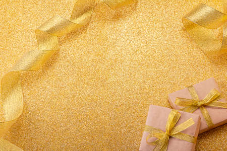 New Year's image for congratulations and inscriptions on a golden glowing background, decorated with gifts and ribbonの写真素材
