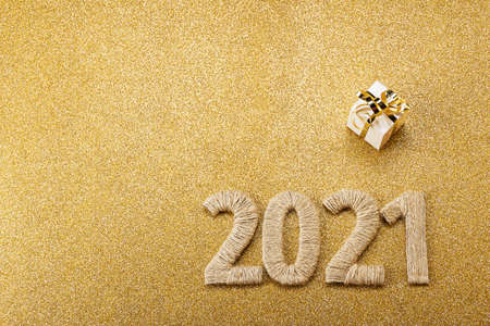 Happy new gold card with handcrafted lettering 2021 and gift. Space for text. Top view