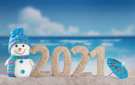 New year 2021 and snowman with and beach umbrella on sea backgroundの写真素材