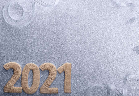 New year 2021 twine inscription on silver sparkling background with bright ribbonの写真素材