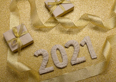 Happy New Year. Craft gifts and handcrafted lettering 2021 on gold background. Top viewの写真素材