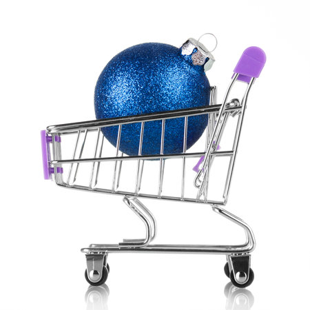 Small decorative shopping cart with blue christmas ball isolated on white backgroundの写真素材