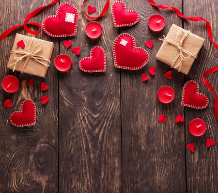 Red hearts, gift boxes and candles on wooden boards. Empty space for congratulations on valentine's day. Top viewの写真素材