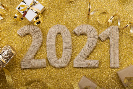 Lettering 2021 from handmade twine on gold with champagne bottle and ribbonの写真素材