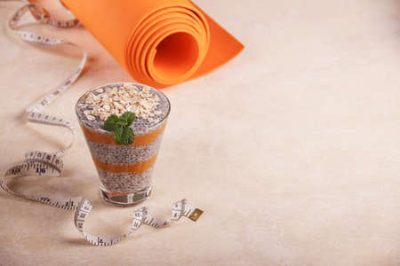 Healthy lifestyle concept. Healthy chia and yogurt dessert and yoga mat on a light tableの写真素材
