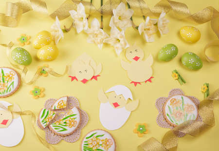 Happy easter. Hand painted gingerbread, easter eggs, spring flowers on yellow background