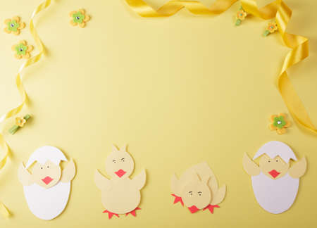 Bright composition of handmade chickens, golden ribbon and empty space for an inscription on a...