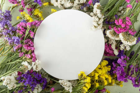 Bright card with an empty place for an inscription and multi-colored dried flowers