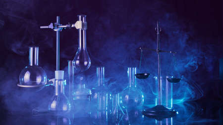 Chemical laboratory. Various test tubes and flasks, laboratory equipment in smoke with blue backlightの写真素材