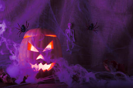 Halloween traditional holiday. Pumpkin jack lantern with glowing eyes and blue smokeの写真素材