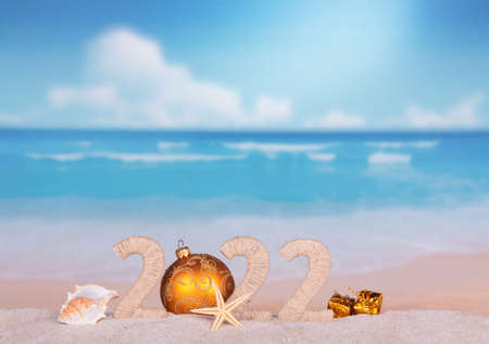New Year 2022 on a hot beach with seashells and starfishの写真素材